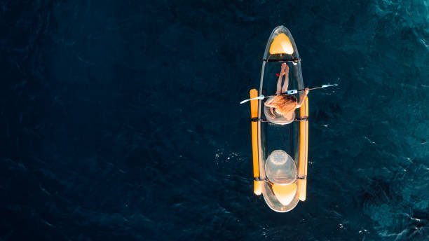 Woman floating on transparent kayak in hrazdan river.