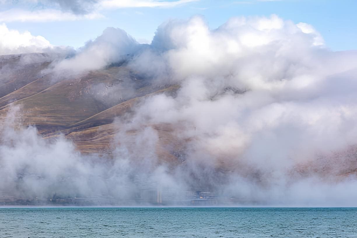 Armenia, Gegharkunik Province. Clouds and mist over Lake Sevan.