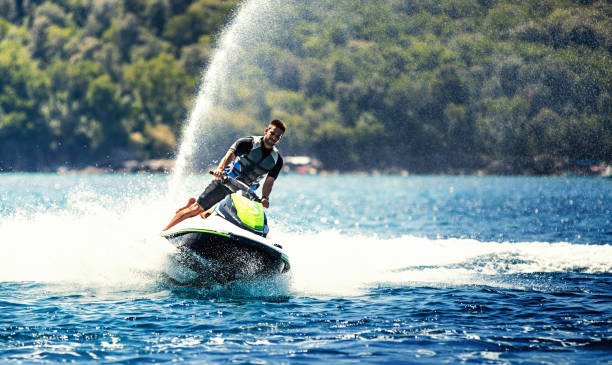 Closeup front view of a young man riding a jet ski on a sunny summer day at Sevan
