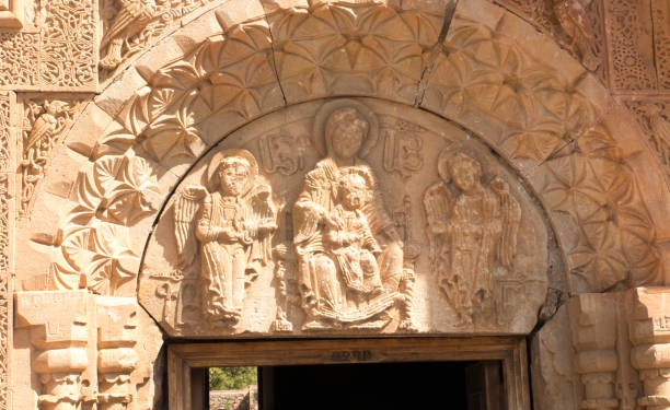The relief icon of tympanium of Surb Astvatsatsin Church depicts the Virgin Mary with Jesus Archangels Gabriel and Michael on the sides surrounded by complex reliefs. Noravank Monastery Vayots Dzor Armenia.
