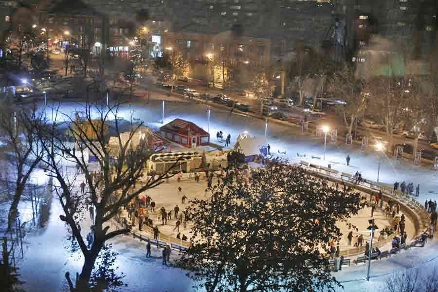 Families ice skating at Swan Lake in Yerevan at night